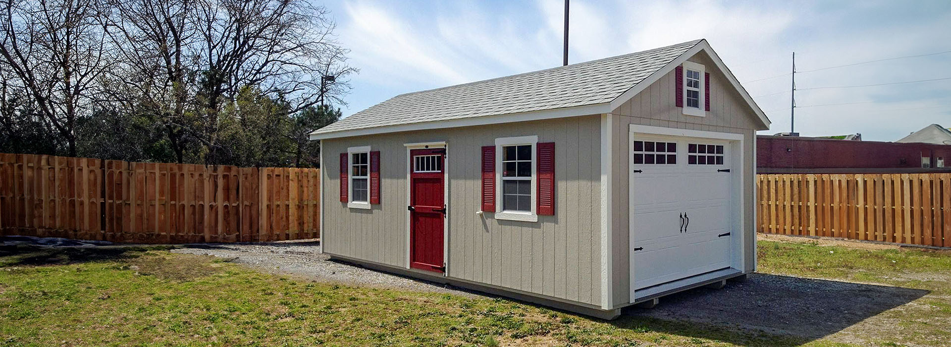 Wooden storage sheds and portable barns on a sunny Georgia lot
